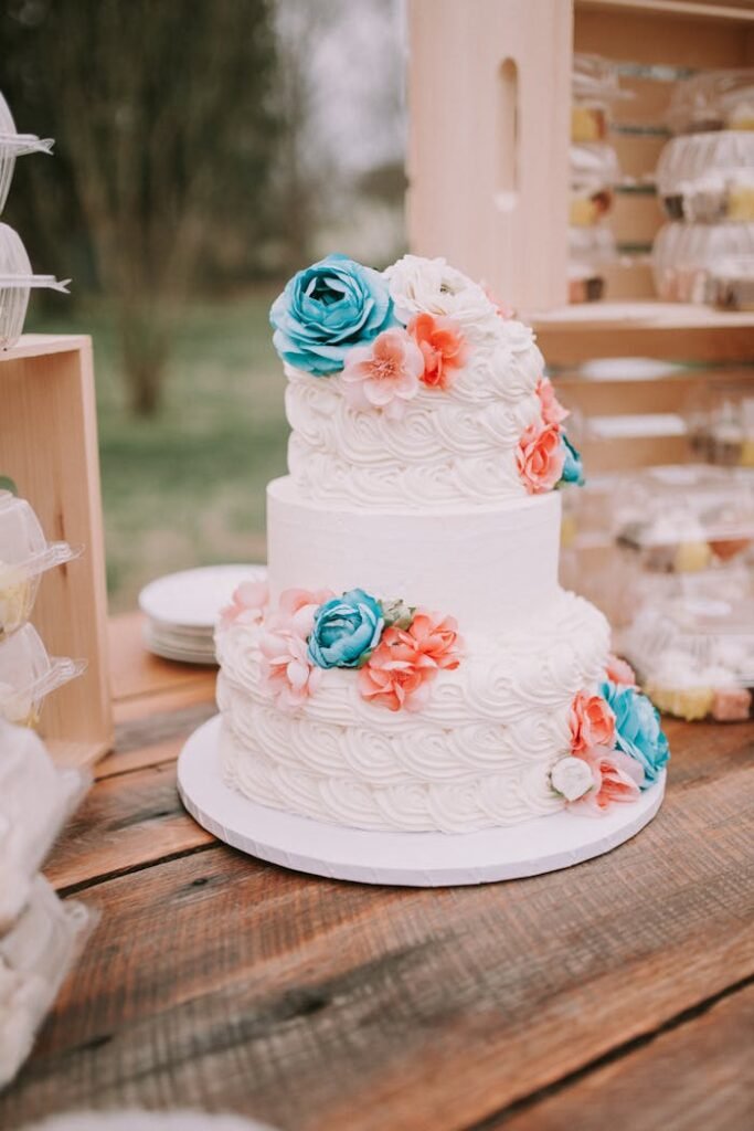 A Wedding Cake with Flowers on a Wooden Table